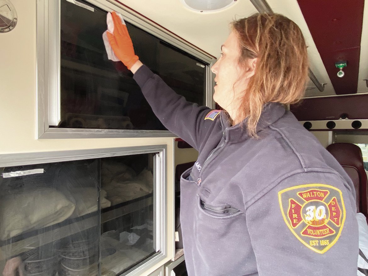 Walton EMS Squad Captain Jessica Gilmore decontaminates the rig with donated antibacterial/antiviral wipes following an ambulance call on Thursday, April 2.